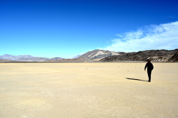 single person standing on the Racetrack Playa in the Death Valley National Park - one man exploration the sailing stones, a phenomenon in the desert, a mysterious travel destination in California