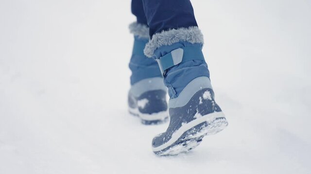 Person In Blue Winter Boots Walking Through Snowscape Town Near Cascade du Rouget In France. - Close Up Shot