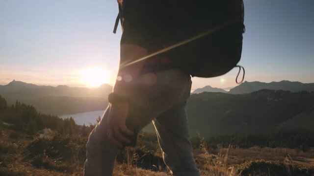 Young Man Walking In The Mountain With Parachute Bag And Helmet At Dusk In Chamonix, France. - close up