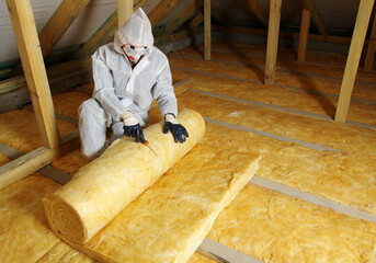 Worker in protective respirator insulating glass wool insulation