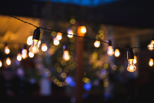 Outdoor String Lights Hanging On A Line In Backyard