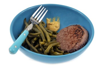 Assiette de haricots verts avec un steak haché en gros plan sur fond blanc
