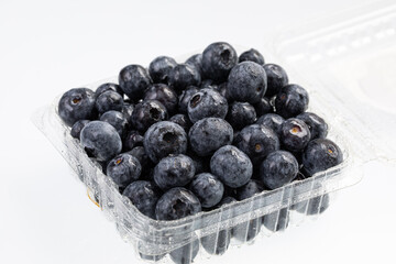 fresh blueberries in a plastic container isolated on white 
