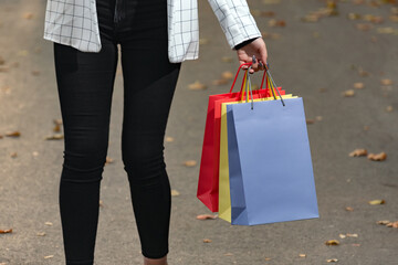 Multi-colored paper shopping bags in female hand. Sale and shopping