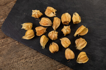 dried physalis arranged on a black slate 