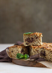 Oatmeal squares with chocolate, light concrete background. Diet bars. Healthy bakery for breakfast or dessert.