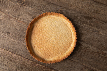 baked, empty tart shell on wooden table 