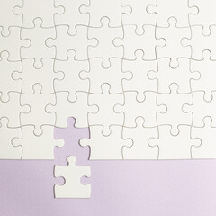 Set of white puzzle pieces and last one piece on purple background. top view