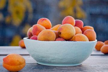 Bowl with apricots on a wooden surface