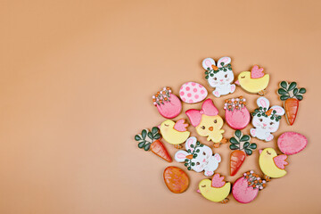 Closeup of variation of different Easter sugar cookies decorated with royal icing. Eggs, bunny, carrots and chicken on yellow background. Lovely sweet gift or postcard