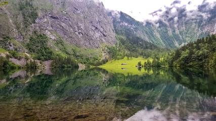 Naklejka na ściany i meble Mountain reflections in the water of the lake Obersee next to the lake Königssee in the nationalpark Berchtesgaden.