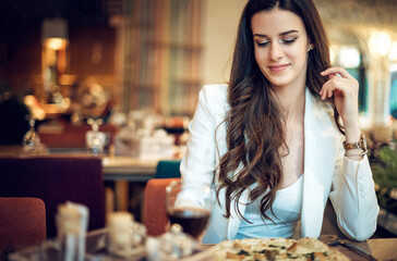 Woman eating pizza in luxury restaurant