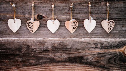 Valentine's Day background. Brown old natural boards in grunge style with wooden decorative hearts. Copy space. Top view. Surface of table to shoot flat lay. Concept love, romantic relation. Banner.
