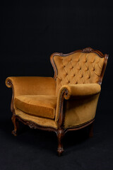 golden Isolated Bergère armchair on black background, side view