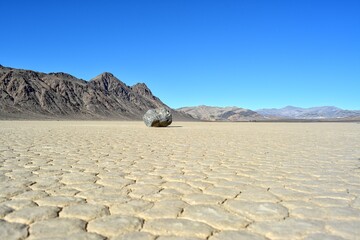 one rock leaving a long trail marks the path of one of the mysterious moving rocks on Death Valley Racetrack Playa, California