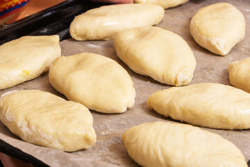 Egg-smeared raw Russian pies prepared for baking
