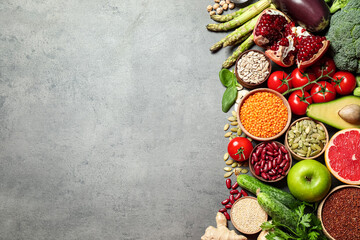 Fresh vegetables, fruits and seeds on grey table, flat lay. Space for text