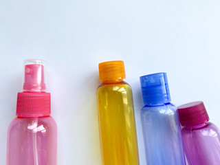Colorful plastic travel bottles. Small containers for liquids like shower gel and shampoo. Face and body care products in compact size.