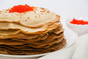 thin pancakes with red caviar on white napkin. The concept of the Russian carnival Maslenitsa