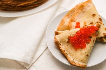 thin pancakes with red caviar on white napkin. The concept of the Russian carnival Maslenitsa