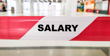 SALARY word on red ribbon indoors during the day