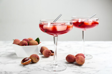 Delicious lychee cocktails and fresh fruits on white marble table