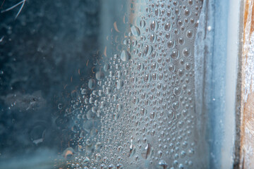 Water droplets from condensation on the old window pane. Drops in soft focus.