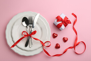 Beautiful table setting for Valentine's Day dinner on pink background, flat lay