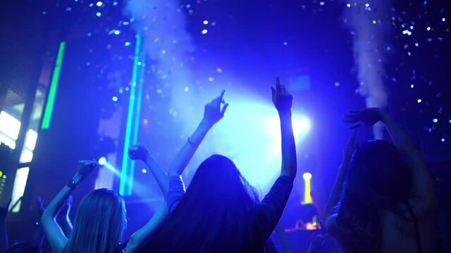 Group of fashionable woman friend celebrating and dancing in night club with illuminated neon night lights. Confidence female enjoy and having fun dance party and nightlife together at disco nightclub