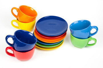 Multi-colored coffee cups and plates on white