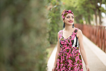 bellissima ragazza sorridente con rossetto rosso vestita con un abito colorato e una fascetta in...