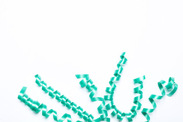 Turquoise serpentine streamers on white background, top view