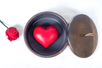 Top view on a red love heart inside a round gift box and a red rose, and a white background. Gift concept for valentine's day, and love  