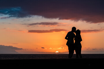 Fototapeta premium Silhouette of couple in love kissing at sunset