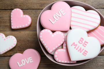 Obraz premium Decorated heart shaped cookies on wooden table, flat lay. Valentine's day treat