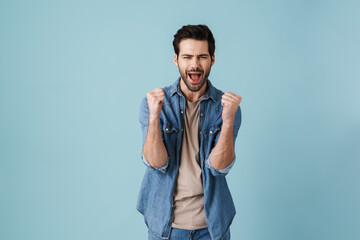 Young handsome unshaven man screaming and gesturing as winner