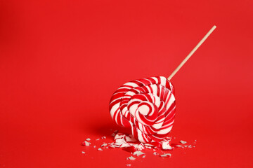 Broken heart shaped lollipop on red background, space for text. Relationship problems concept
