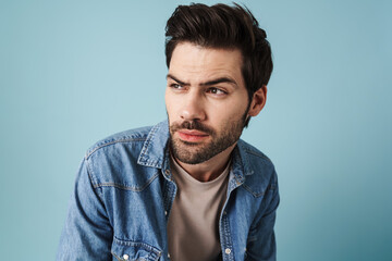 Fototapeta premium Young handsome brooding guy thinking and looking aside