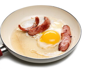 Fried sausages and sunny side up egg in frying pan isolated on white background