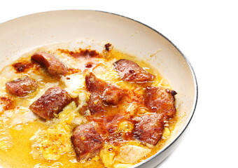 Fried sausages and scrambled eggs omelette in frying pan isolated on white background
