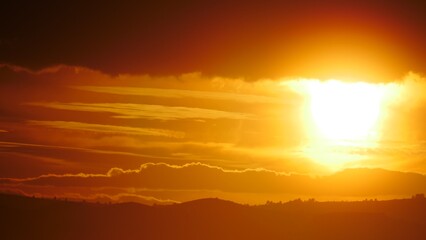 Sunset over hilly coastal land
