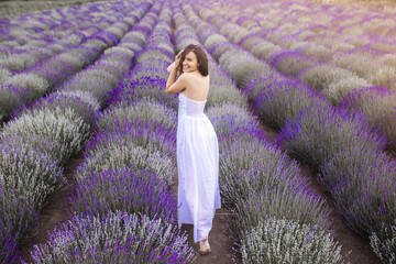 Beautiful young woman on lavender field. Aroma concept. Attractive young female outdoors.