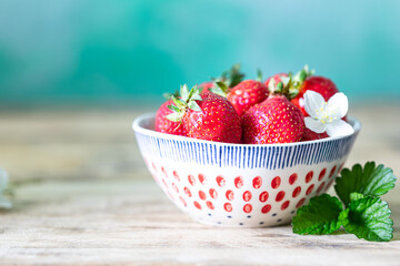 Bowl of strawberries on a wooden background. Copy space