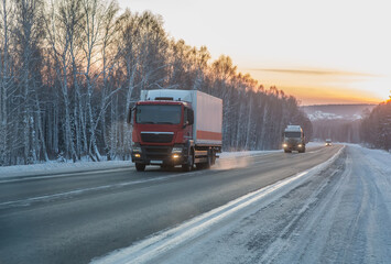 Trucks move in winter along country road