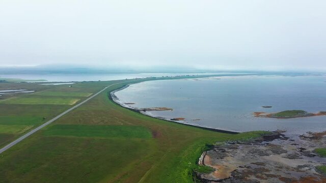 Aerial view towards a small town on the coast of Andoya, dark, overcast day, in Norway - Circling, drone shot