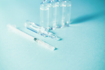 Glass ampoules with liquid on a blue background.