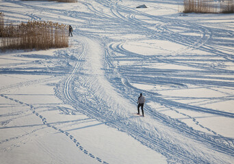 Two skiers skiing on the frozen surface of the river