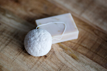 Natural cosmetics on wooden background. Flat lay top view skin care products branding mock up. Natural konjac sponge and natural hand made soap. Healthy lifestyle, zero waste cosmetic routine. 