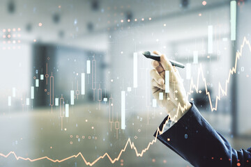 Double exposure of man hand with pen working with abstract creative financial chart hologram on...