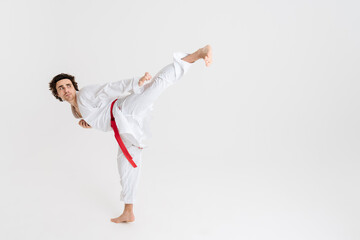 Young caucasian sportsman dressed in kimono practice in karate